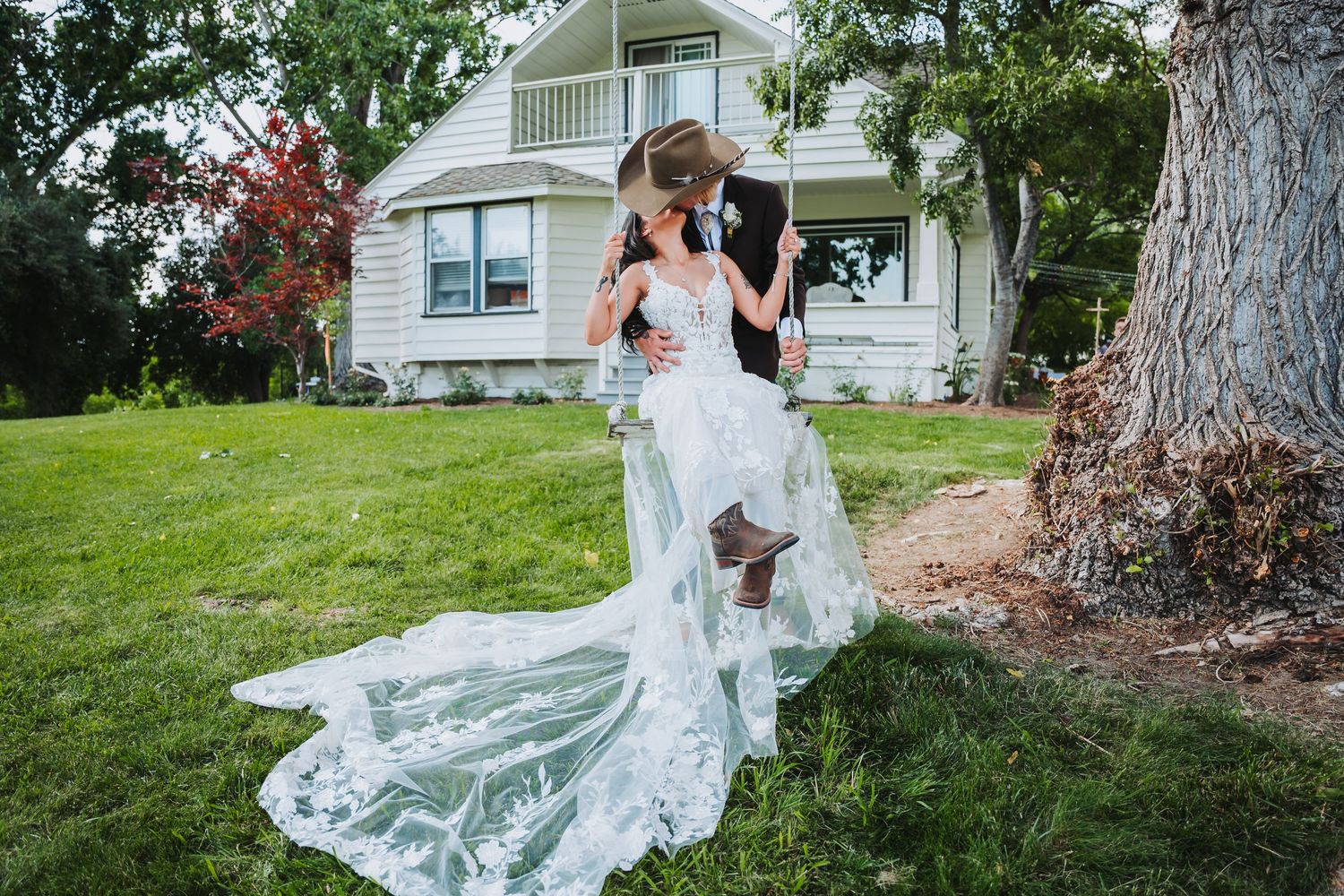 Bride and groom kissing on swing