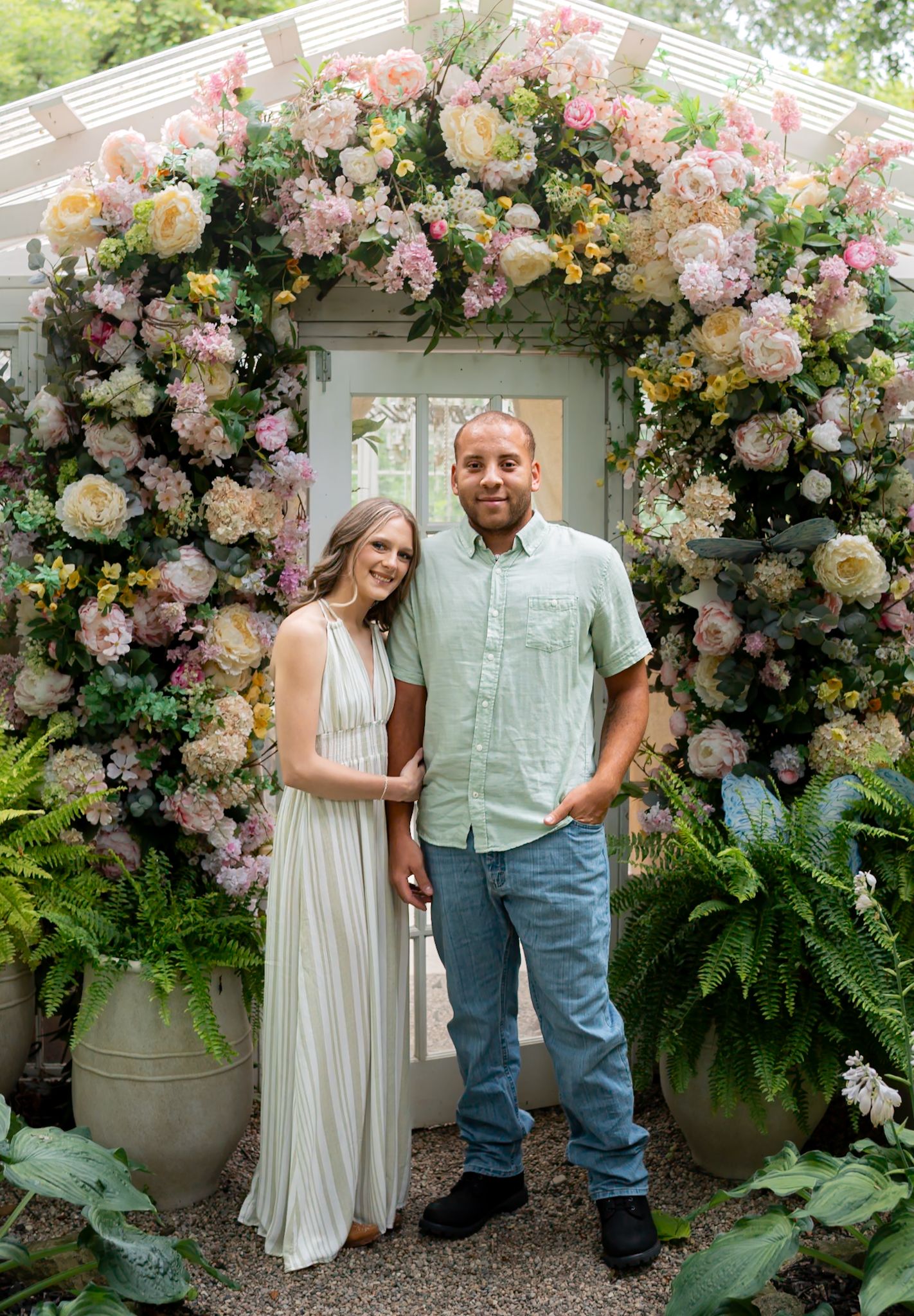 Beautiful floral arch with pink and white roses decorating an outdoor garden setting.