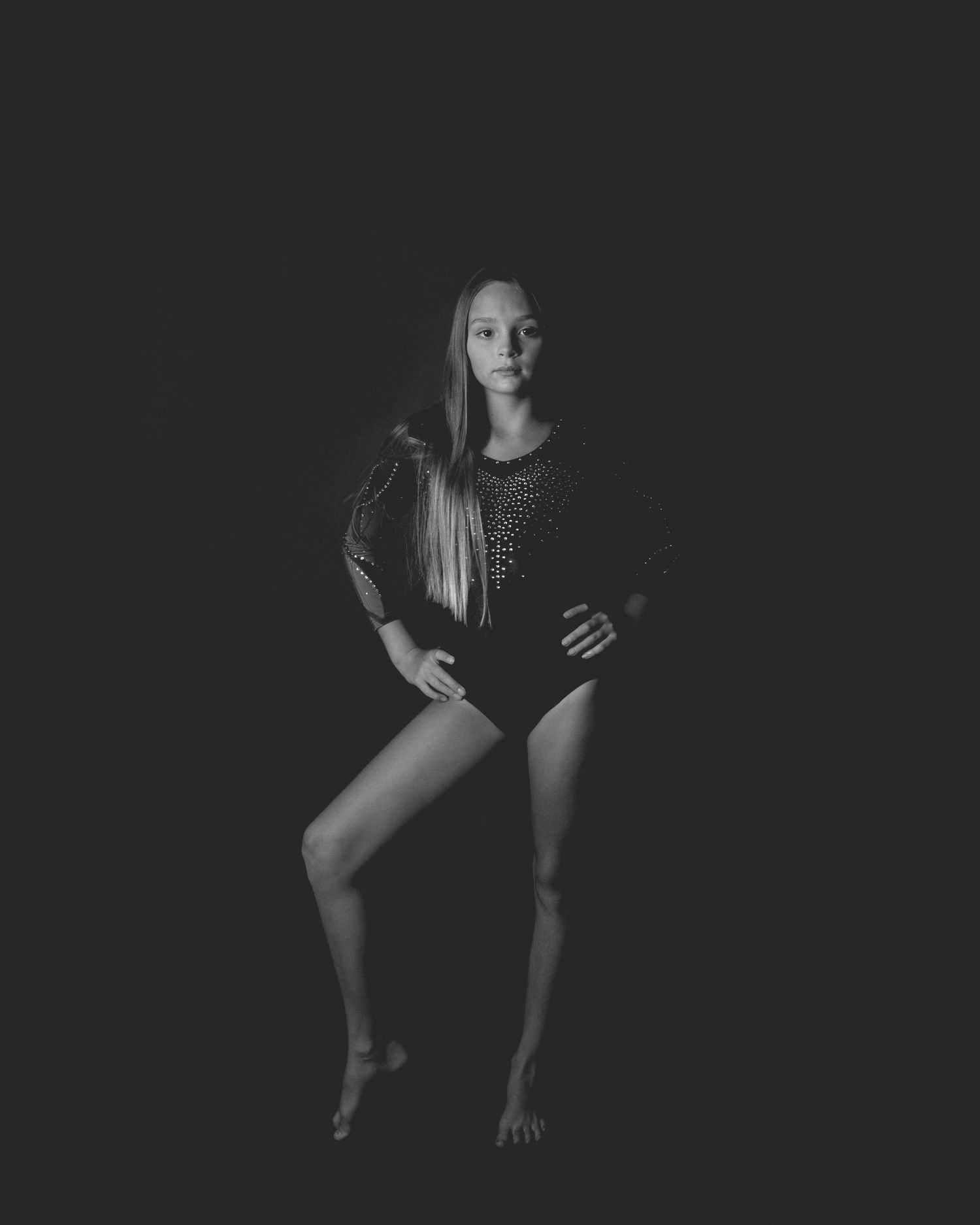 Black and white artistic portrait series showing dramatic poses against dark background with moody lighting.