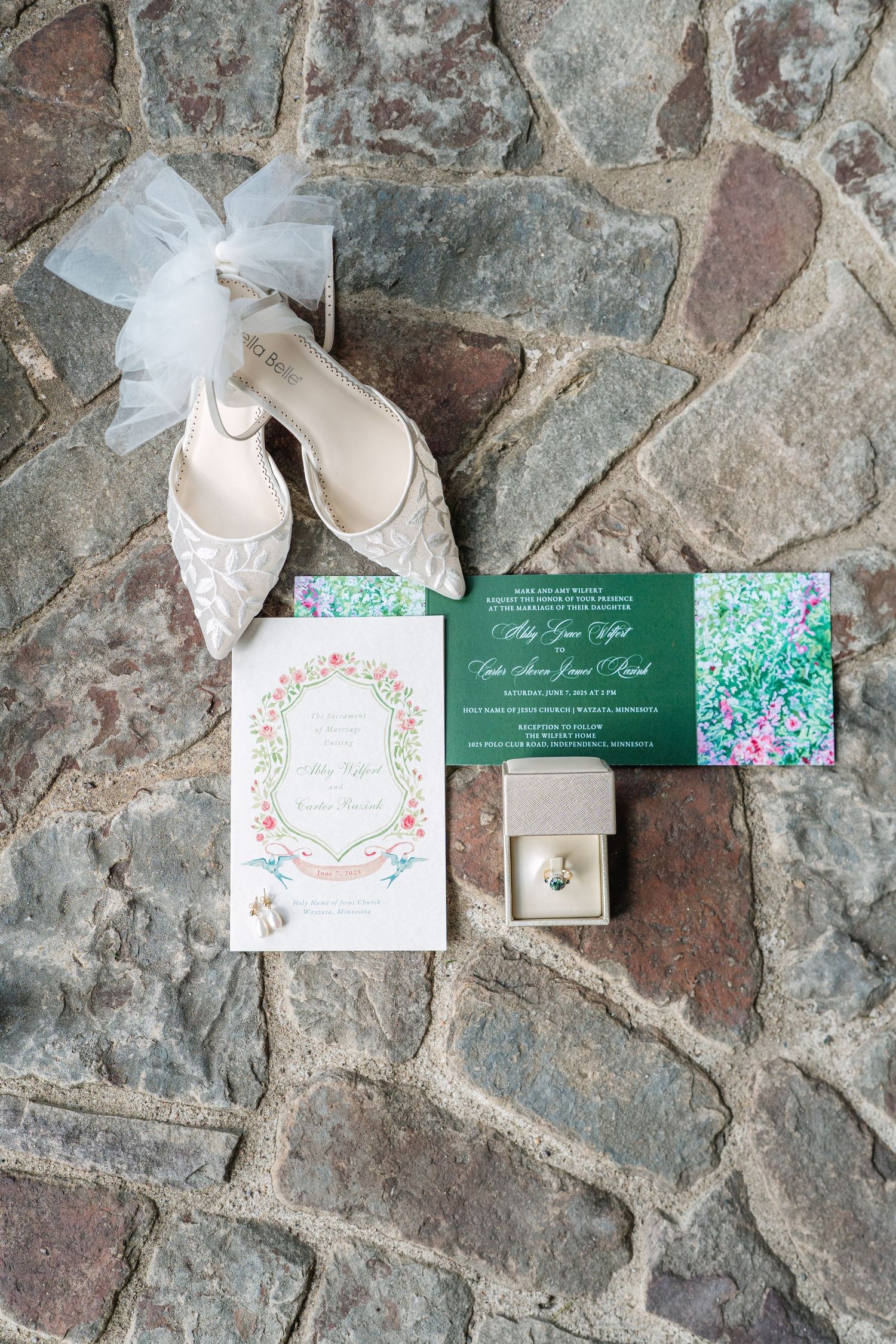 Flat lay of a romantic wedding invitation suite designed by bride Abby Grace Designs, featuring green, blush, and fuchsia pink details