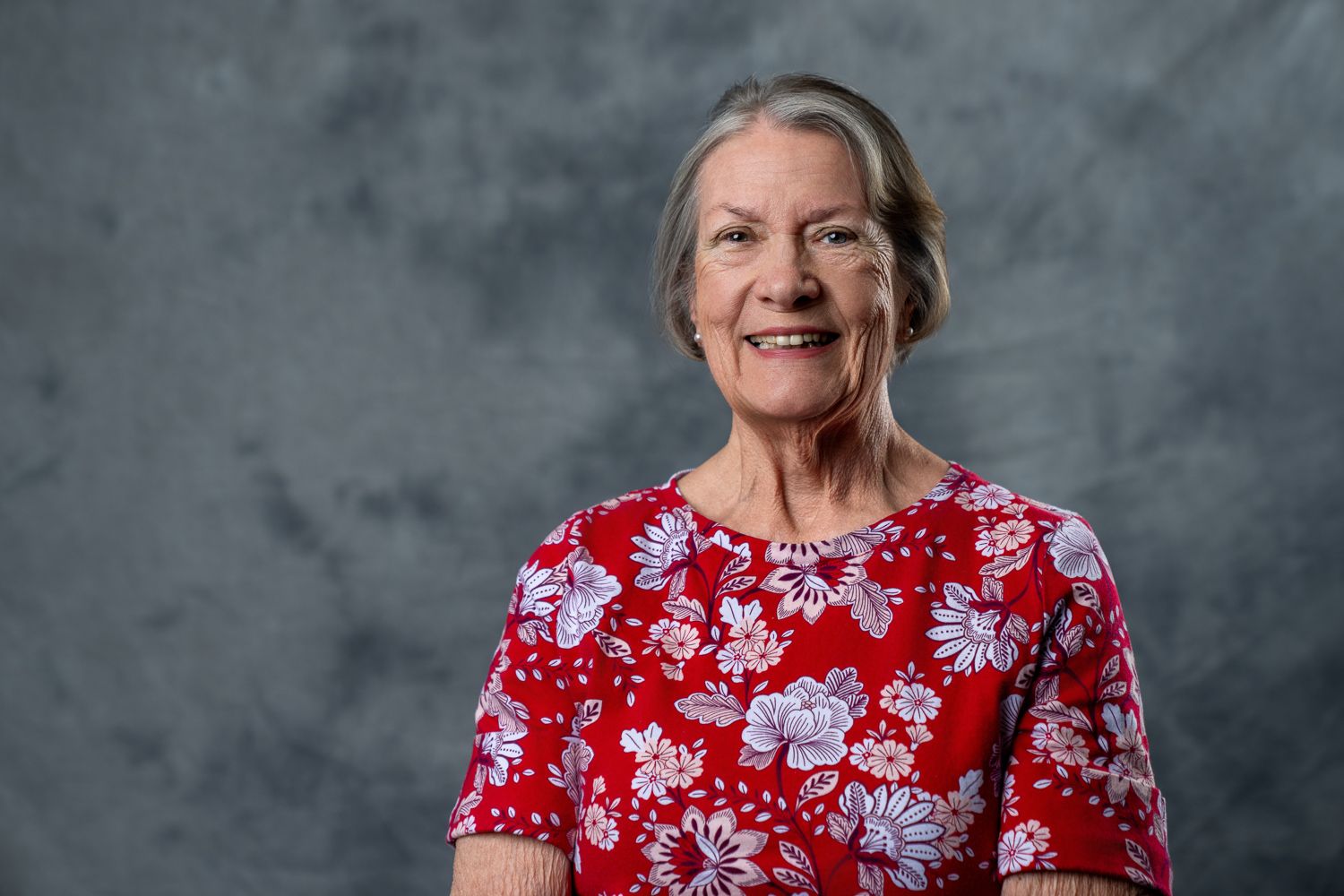 Portrait series showing person in red floral dress against grey background.