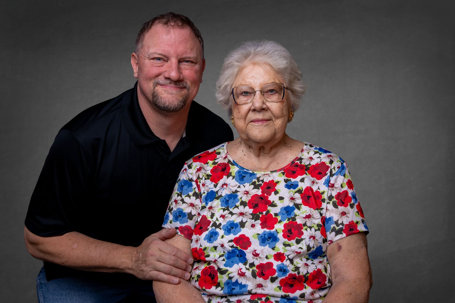 Portrait series showing two people posing together against dark grey studio background.
