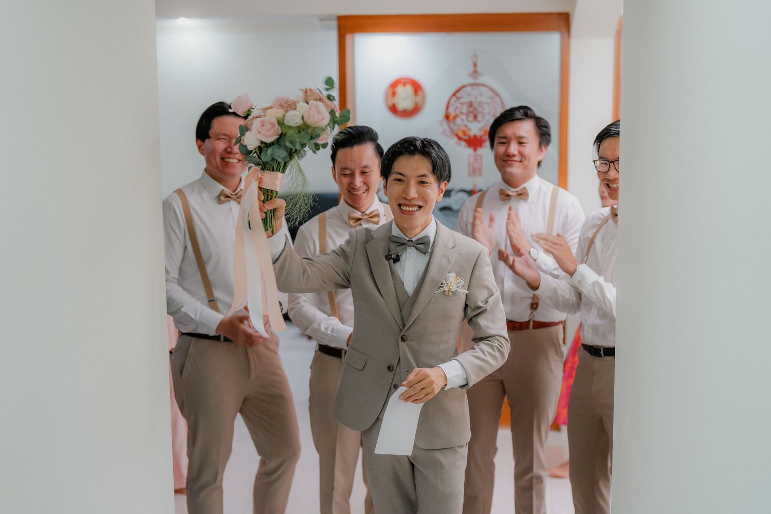 A celebratory moment with groomsmen in matching suits posing indoors.