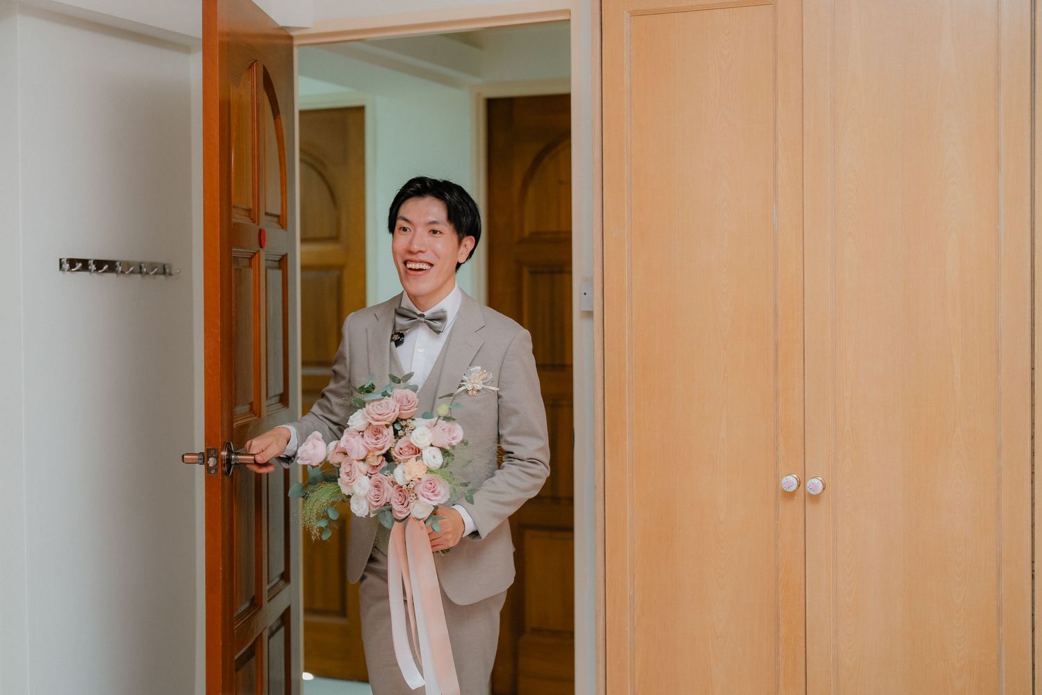 A couple in wedding attire sharing a tender moment in a warmly lit interior setting.