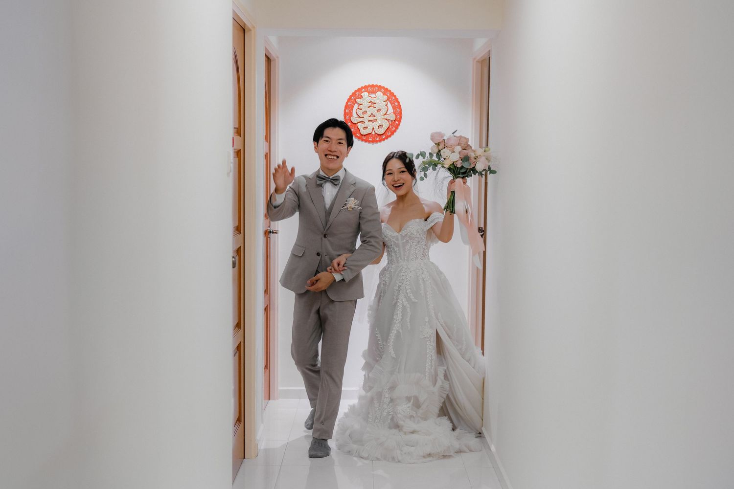A couple walking through a bright hallway decorated with traditional Chinese elements.