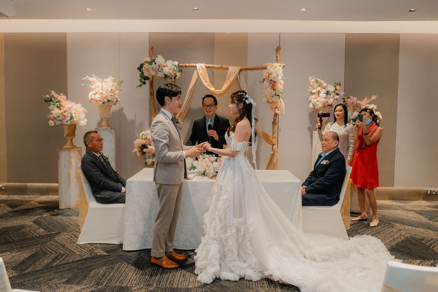 Wedding celebration in an elegant ballroom with guests and decorative elements.