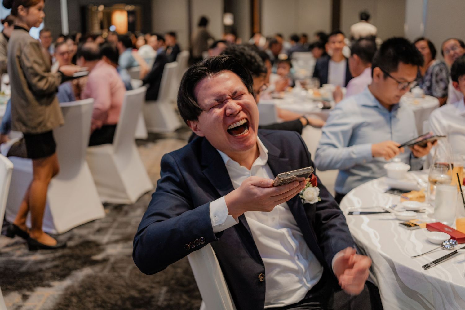 Wedding reception guests enjoying food and drinks at decorated tables.