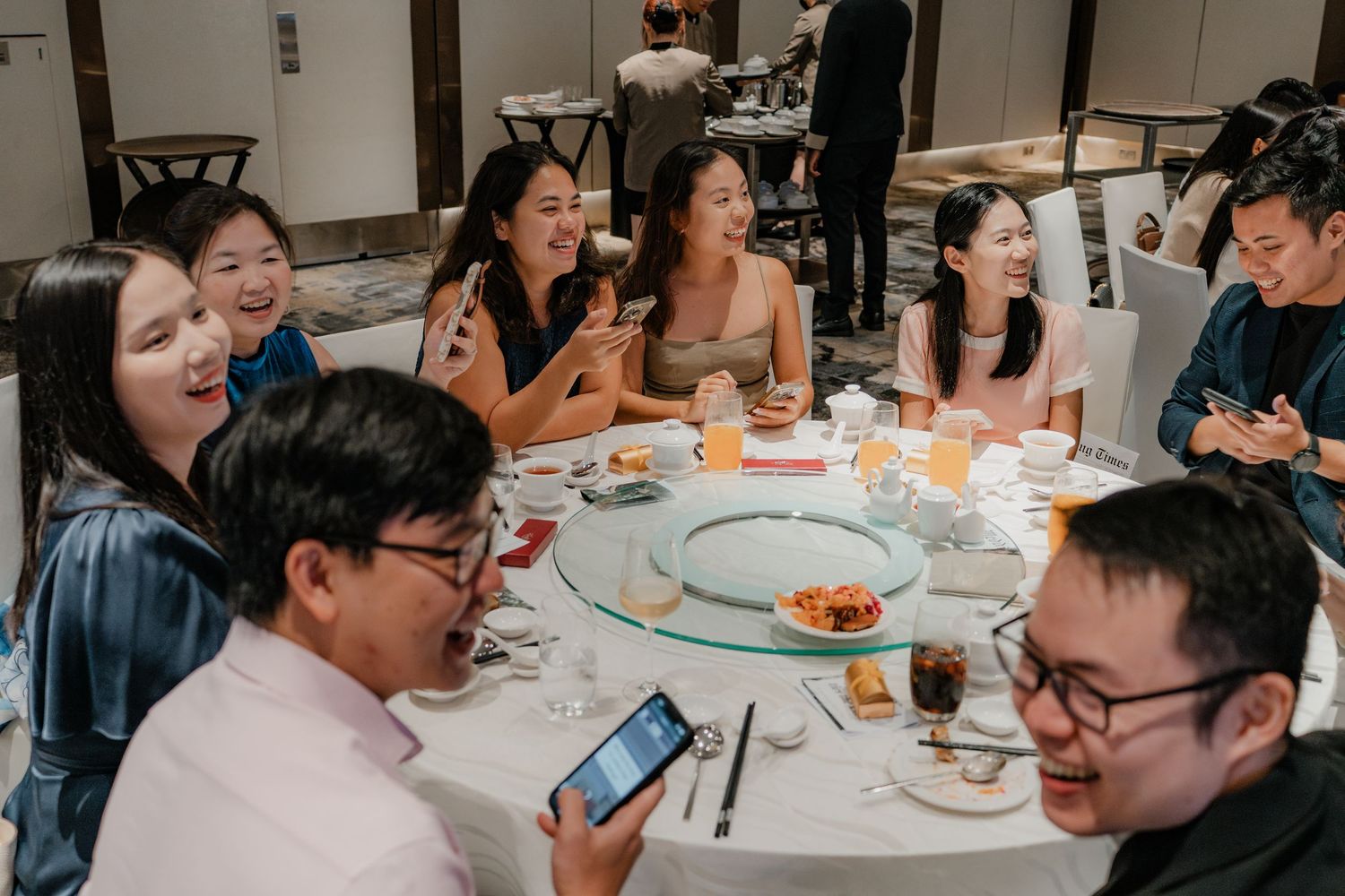 Wedding guests enjoying a meal at round tables during the reception celebration.