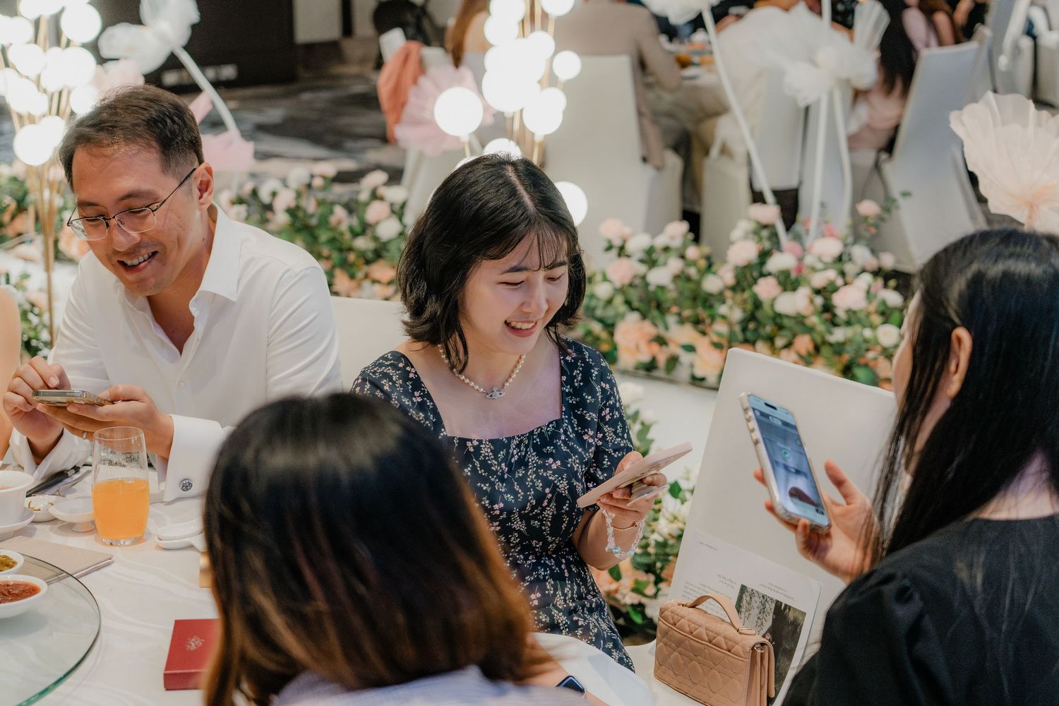 Wedding reception guests enjoying food and conversation at decorated tables.