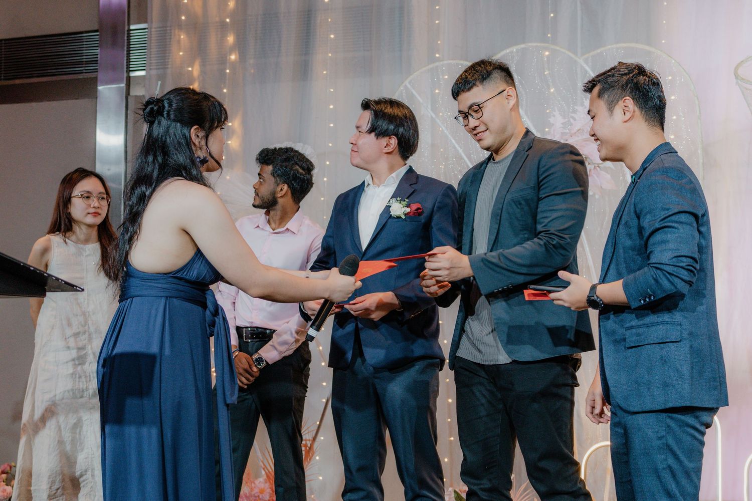 Wedding guests in formal attire participating in a reception ceremony.