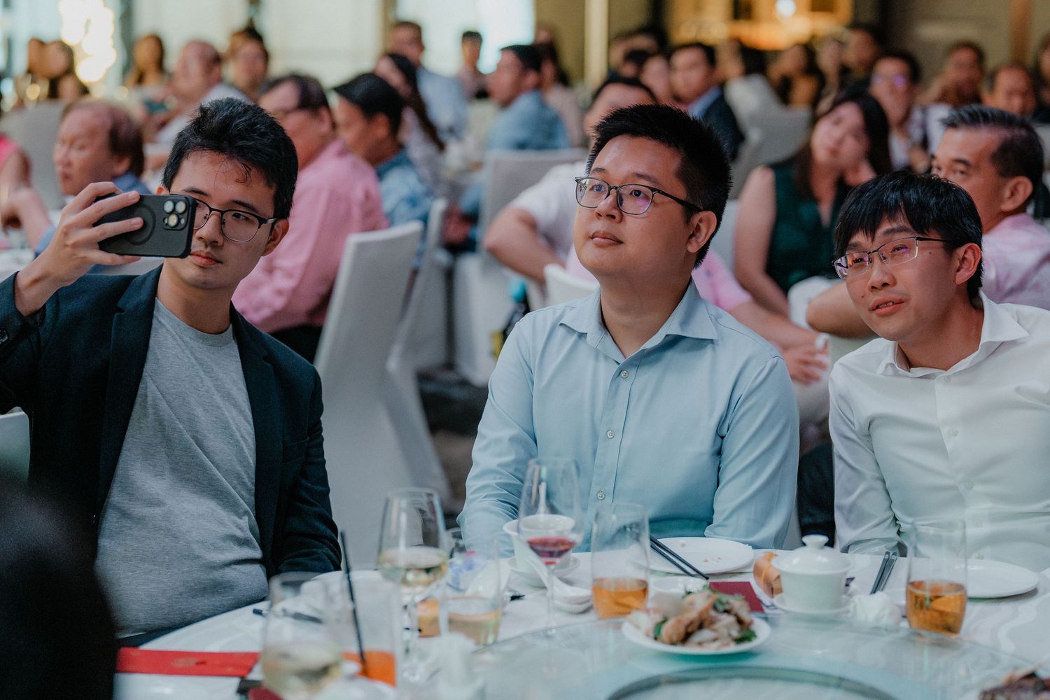 Wedding guests reacting expressively during the reception festivities.