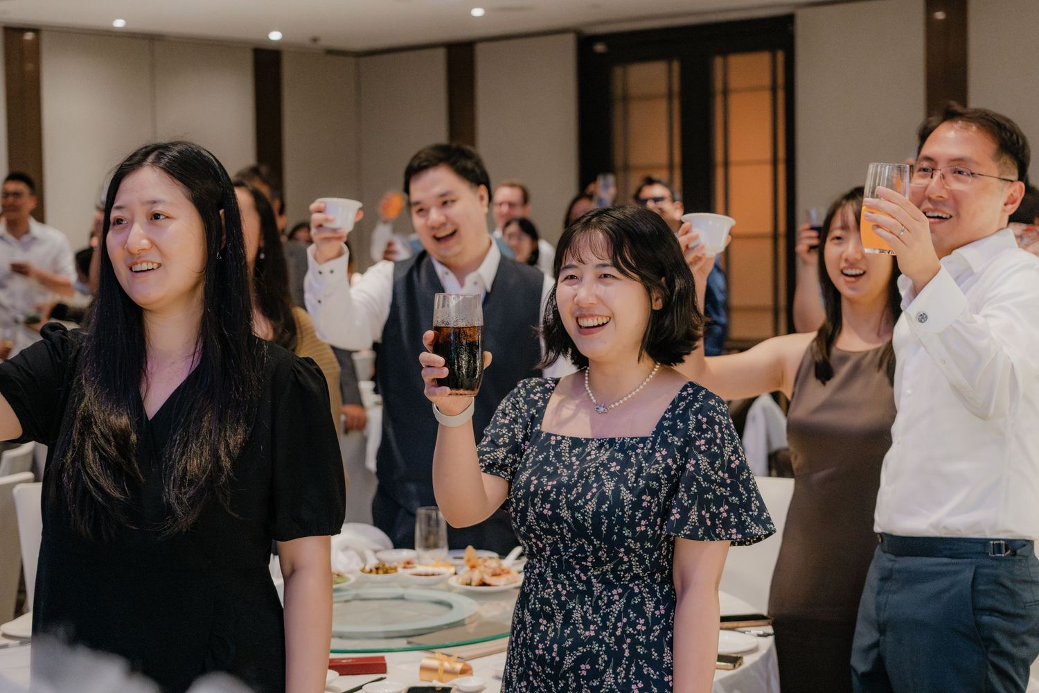 Wedding reception guests enjoying festivities with animated expressions.
