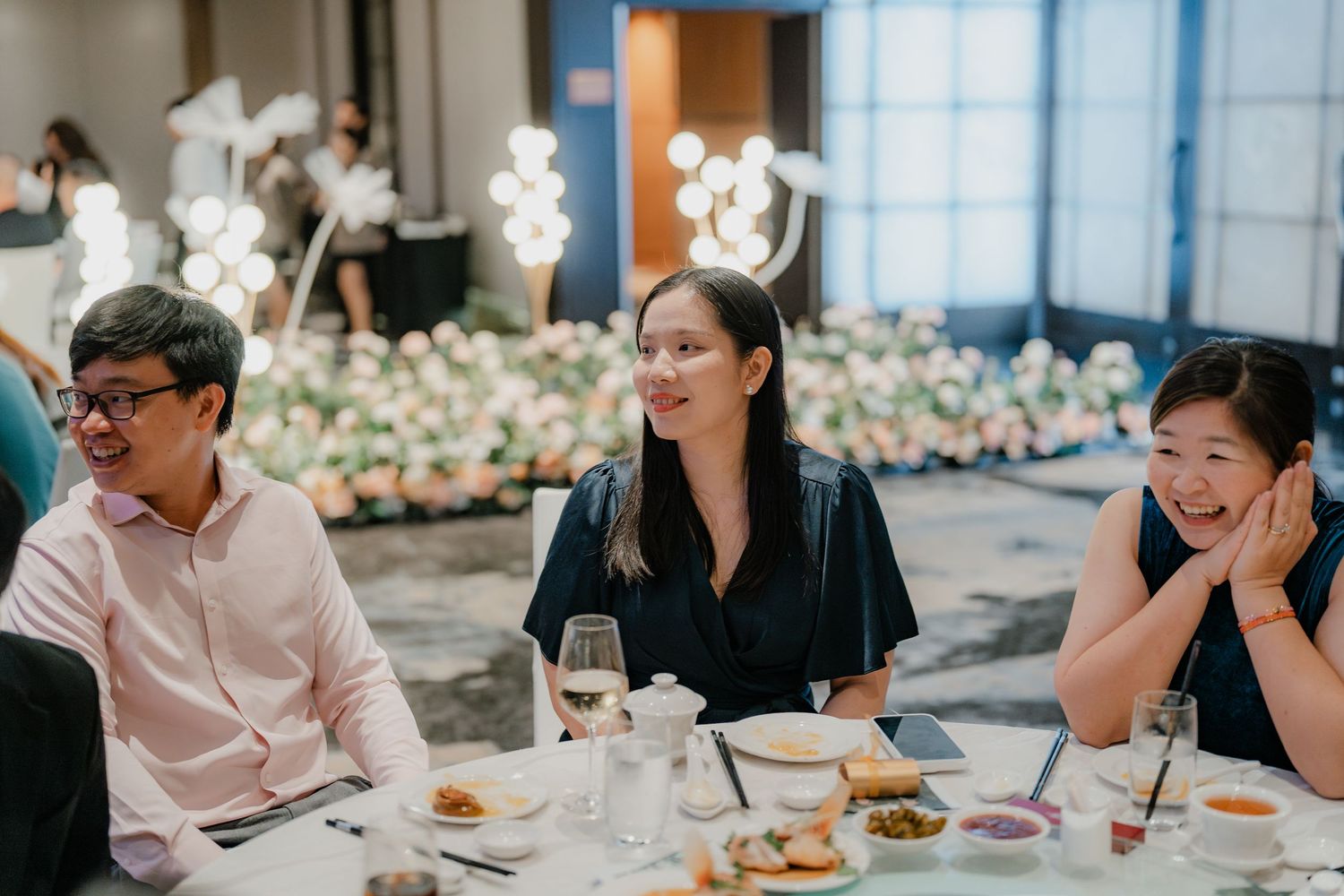 Wedding guests enjoy a meal and conversation at an elegantly decorated reception table.