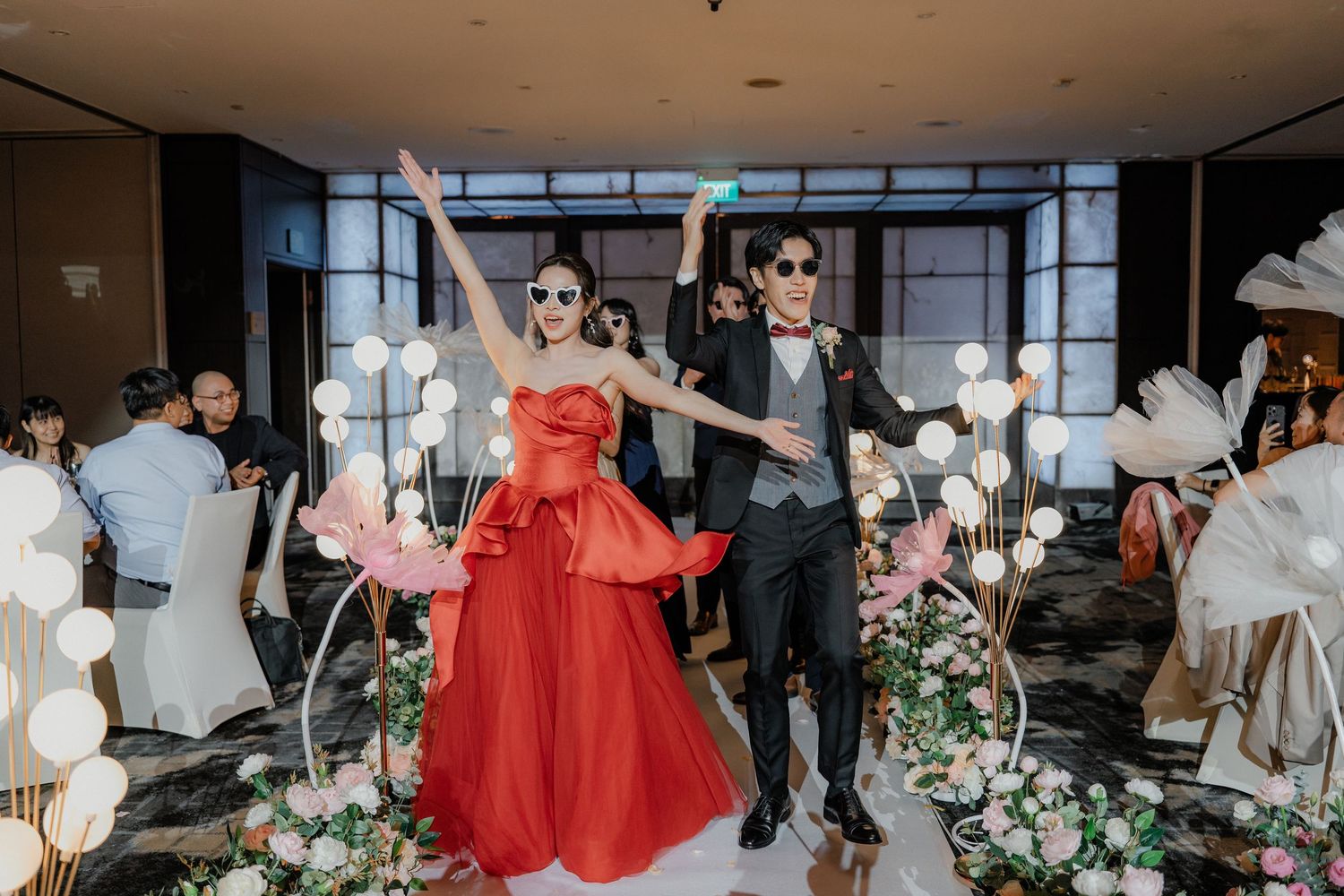 Modern indoor wedding venue decorated with elegant floral arrangements and warm lighting.
