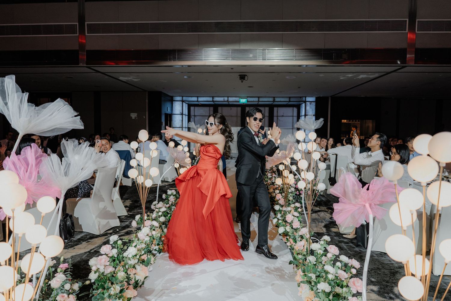 Wedding reception venue decorated with elegant floral arrangements and white balloon installations.