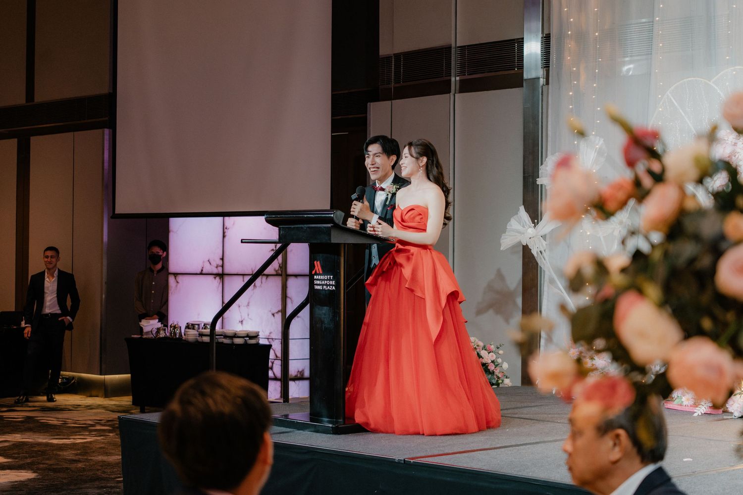 Modern wedding venue decorated with soft lighting and pink floral arrangements.