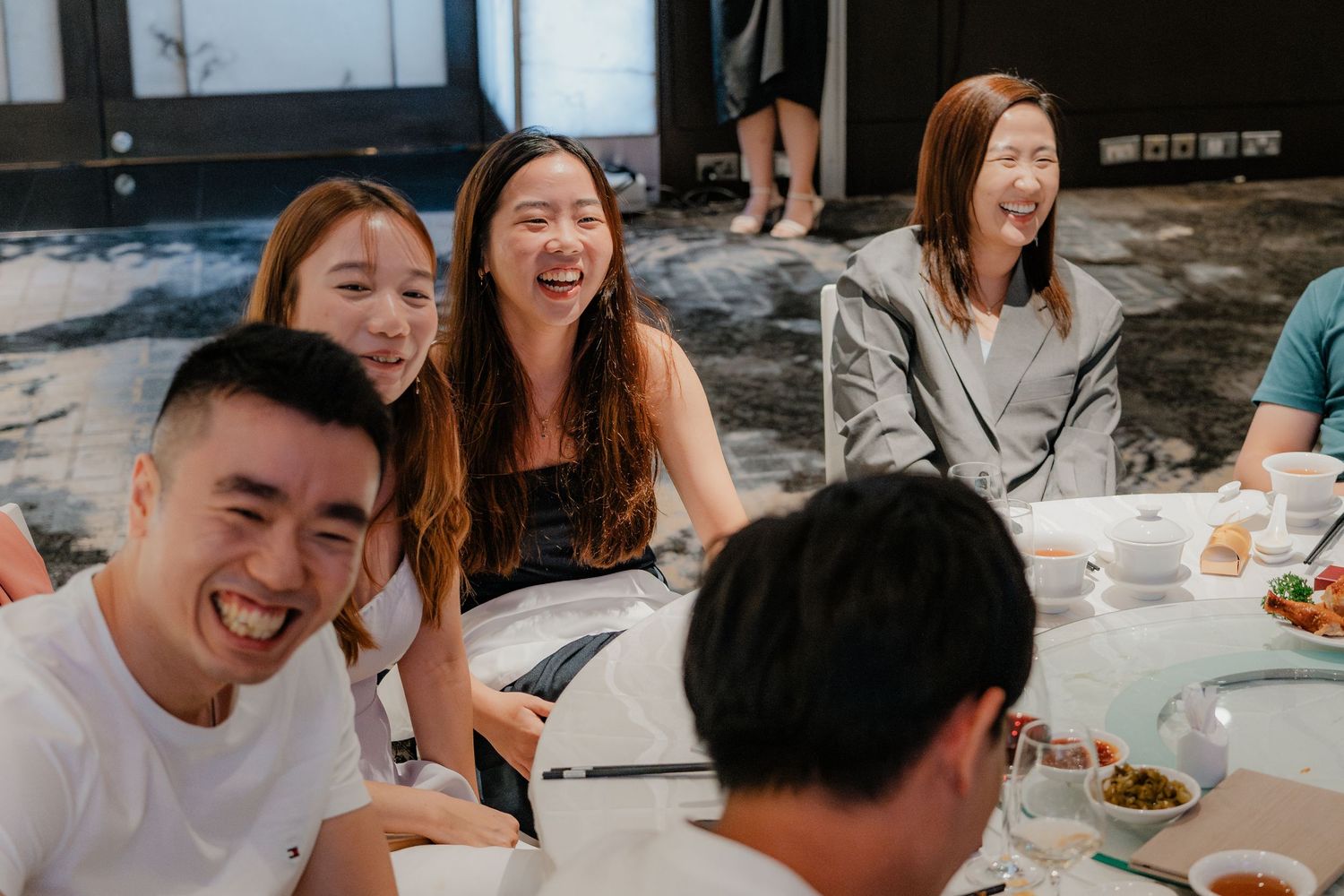 A group of friends sharing laughter and food at an outdoor gathering.
