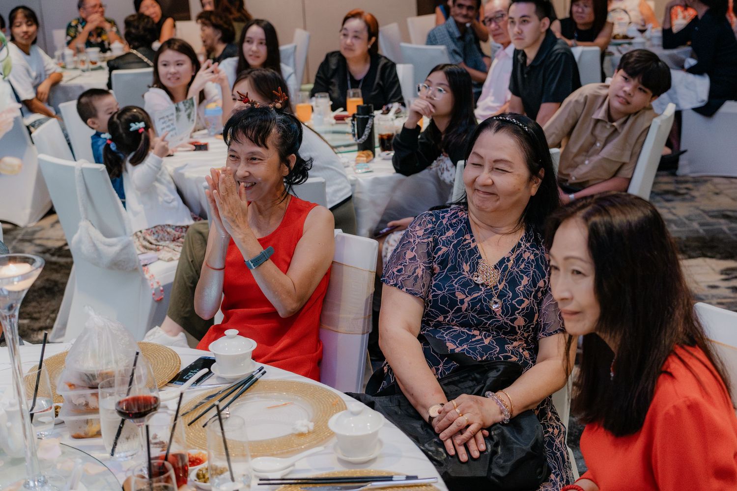 Wedding reception guests socializing at decorated dining tables.