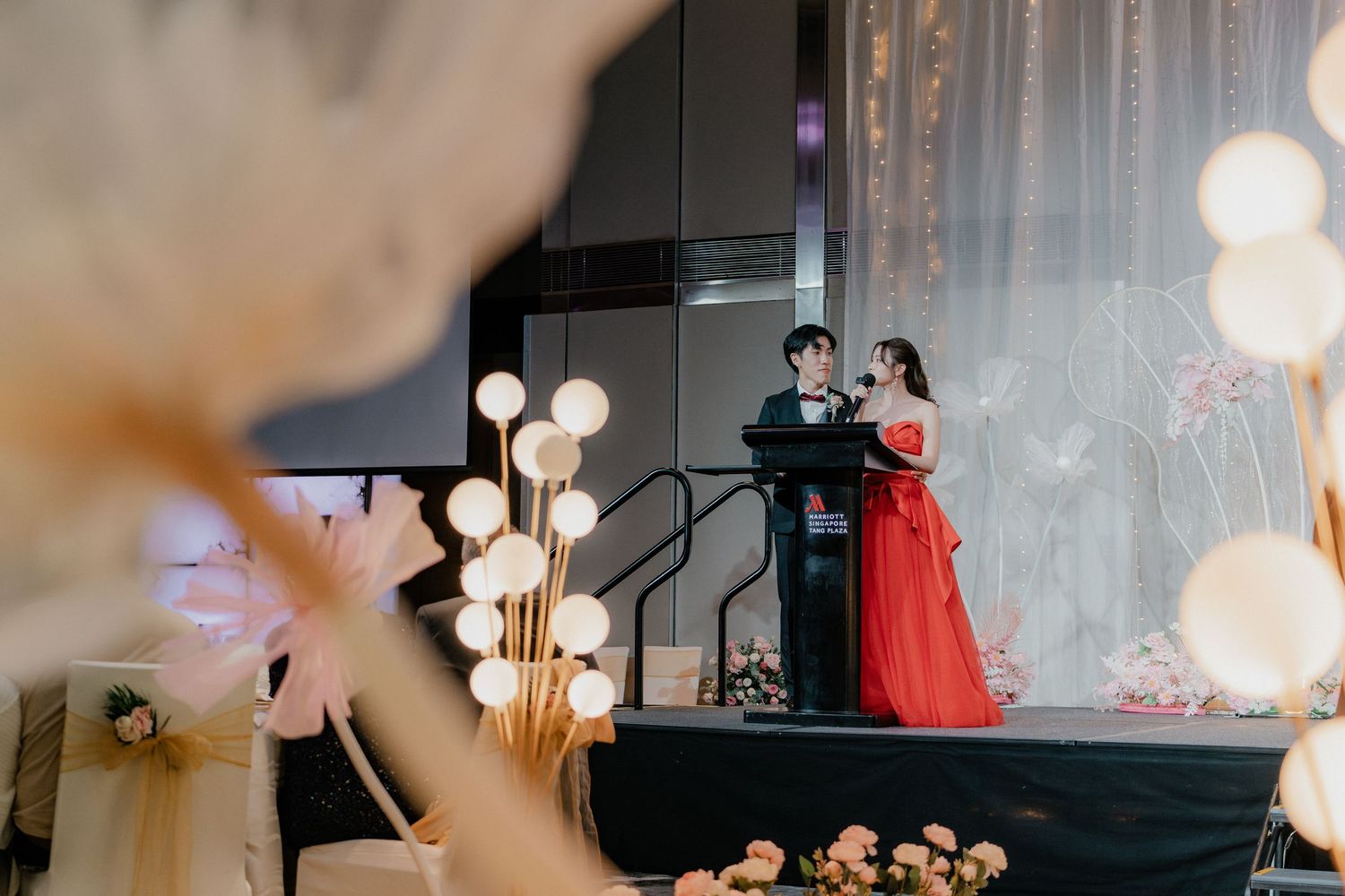 A formal event on stage with decorative globe lights creating an elegant atmosphere.