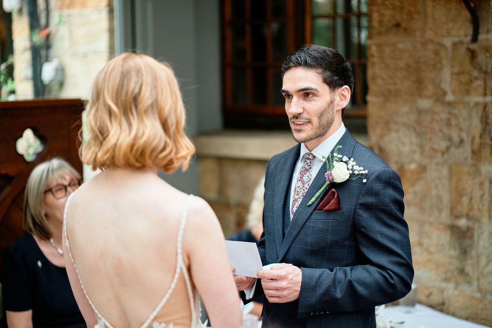 A wedding party having fun dancing and celebrating together at a rustic stone venue during a reception.