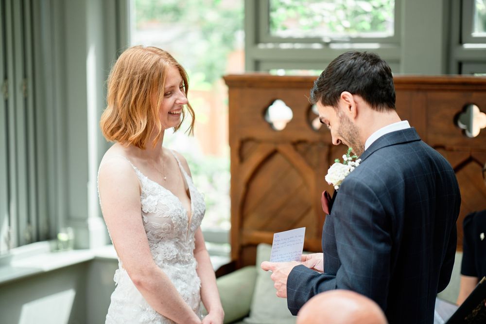 A heartfelt moment during a wedding ceremony as the couple exchanges vows in a naturally lit indoor venue.