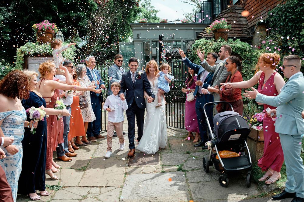A panoramic view of wedding guests lined up along an outdoor path for a celebratory celebration ritual.