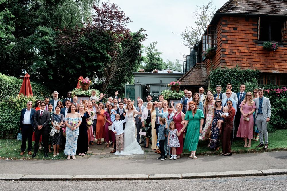 A series of outdoor wedding photos showing groups of guests at what appears to be a rustic venue with brick buildings.