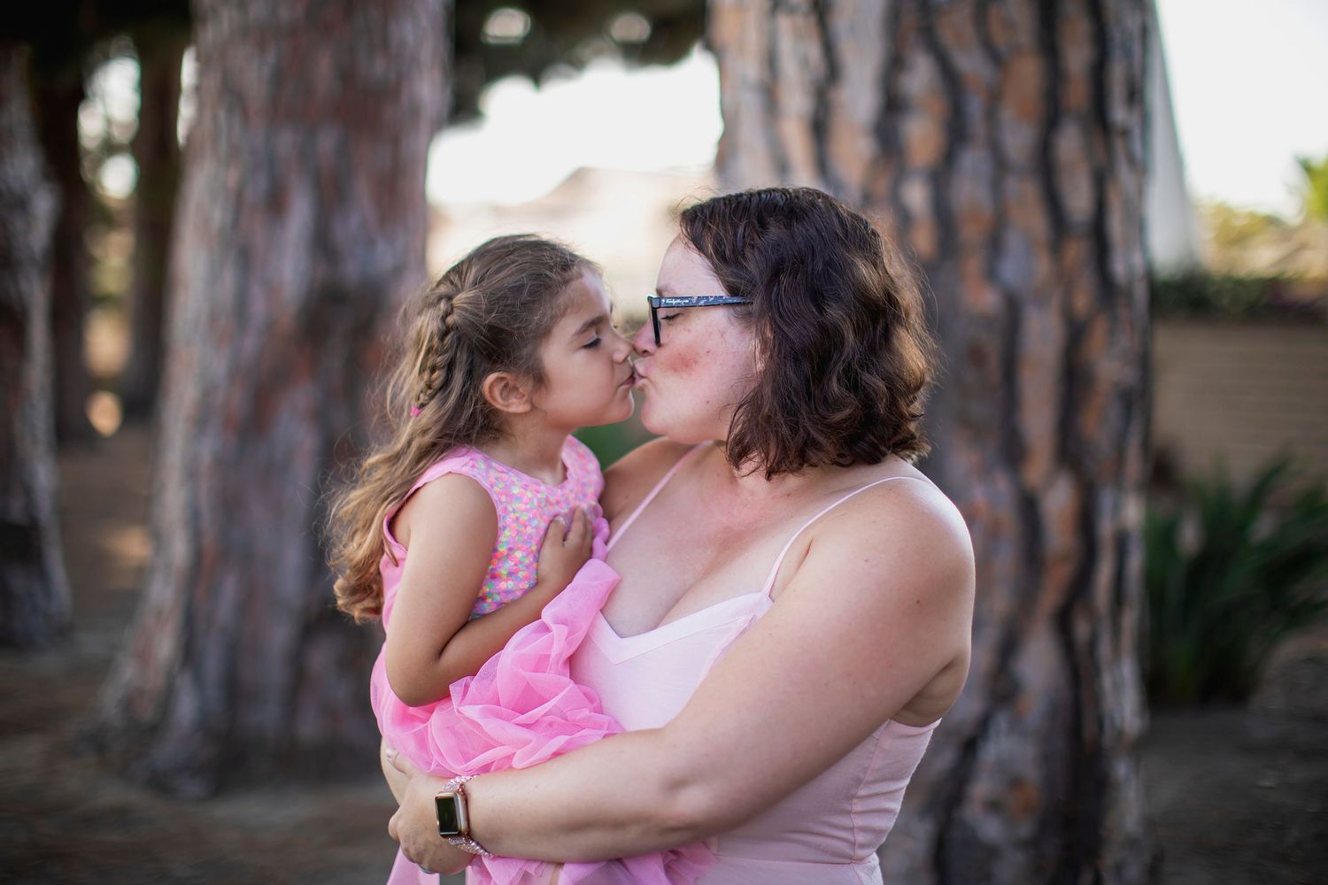 Intimate bonding moment between parent and child outdoors among pine trees.