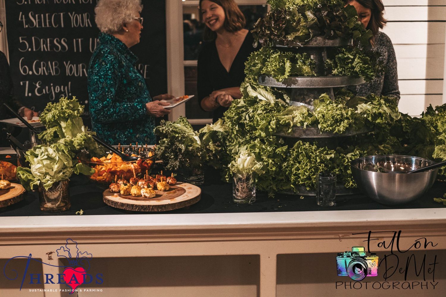 Catered food display with appetizers and greenery at an event.