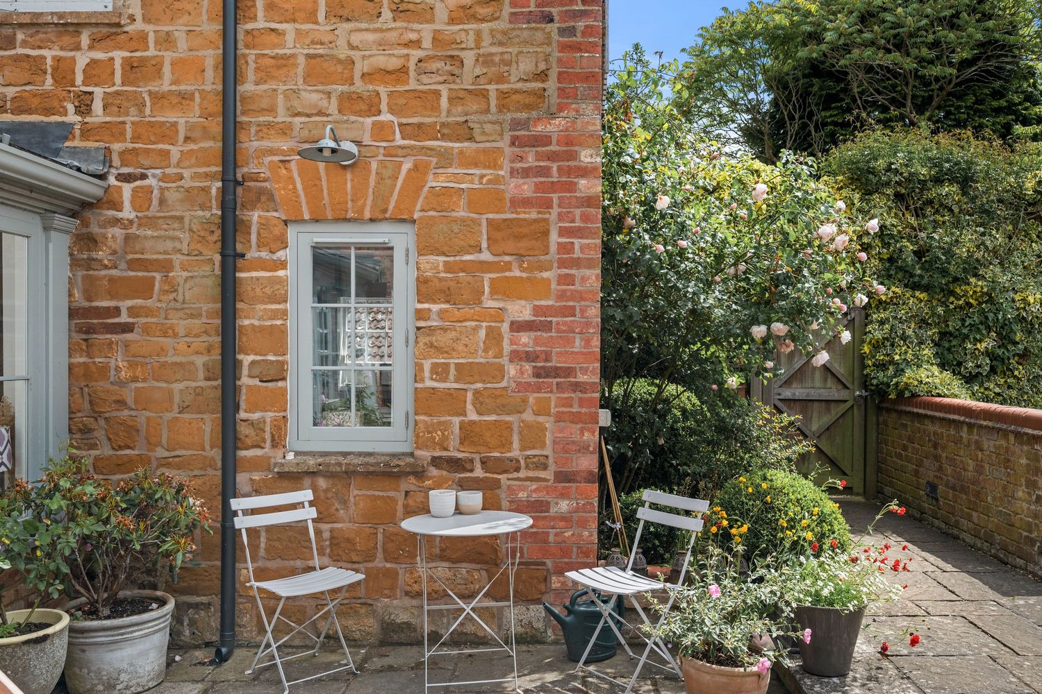 Property photography capturing a chic outdoor seating area in the grounds of a countryside estate for a real estate property listing.