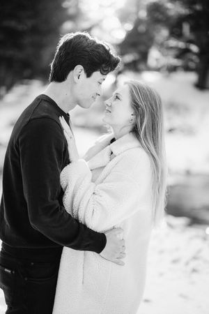 A romantic black and white photo series shows a couple embracing in a snowy winter setting.