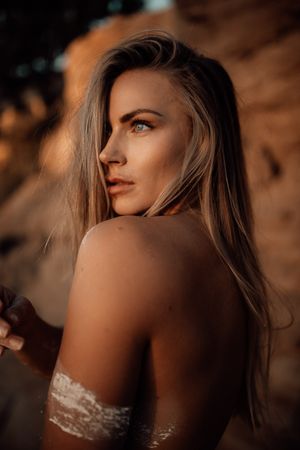 Golden hour portrait captured in warm tones against rocky backdrop.