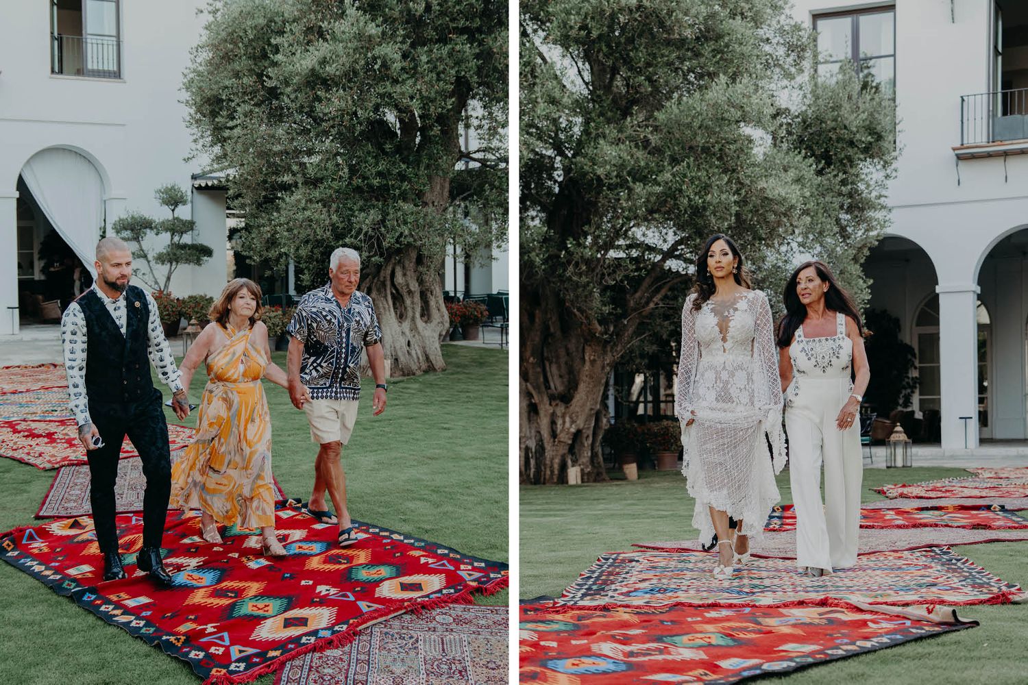 Wedding processional on a path of layered red oriental rugs between arched white buildings and trees.
