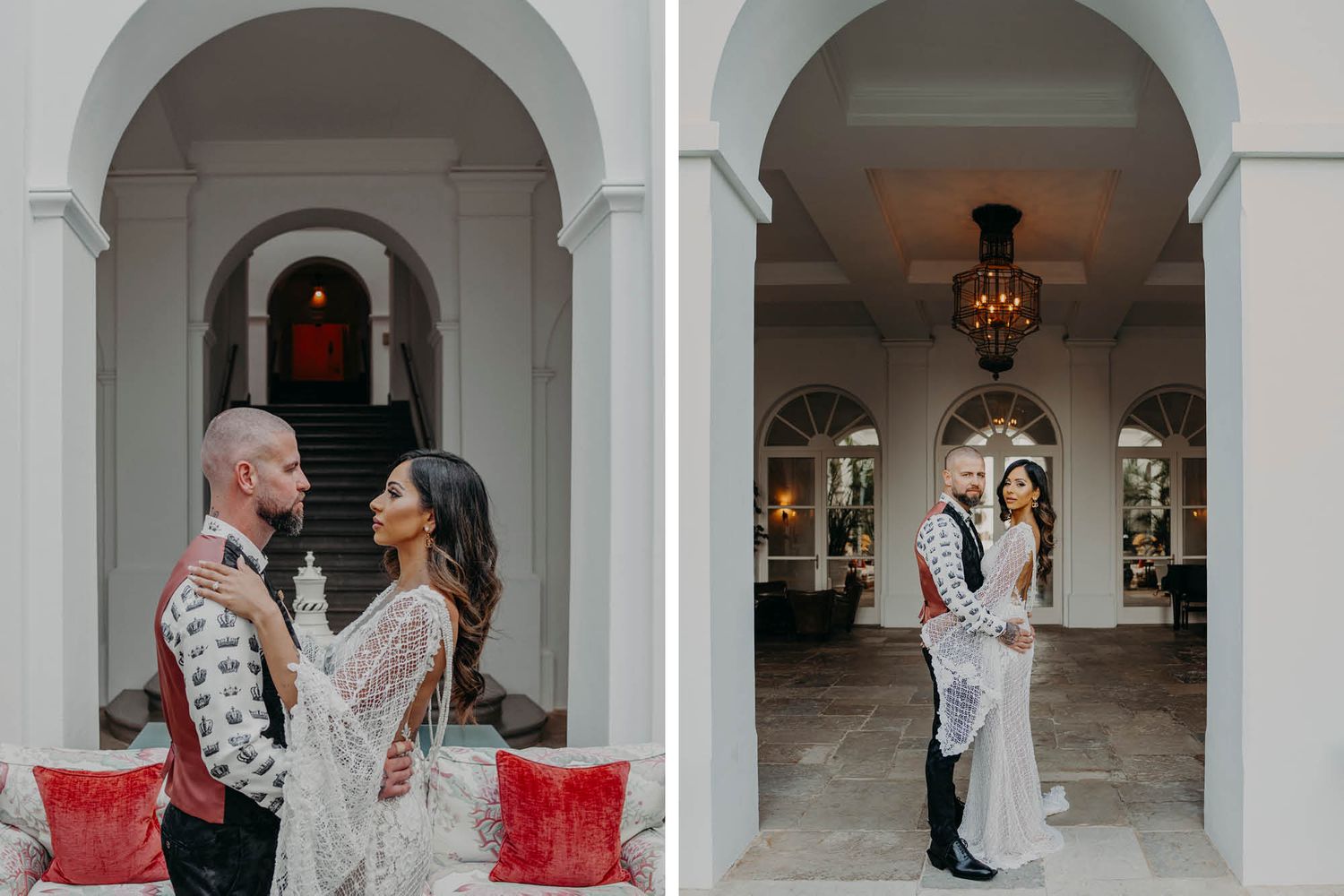 A couple poses in an elegant white archway colonnade with red velvet benches and ornate lighting.