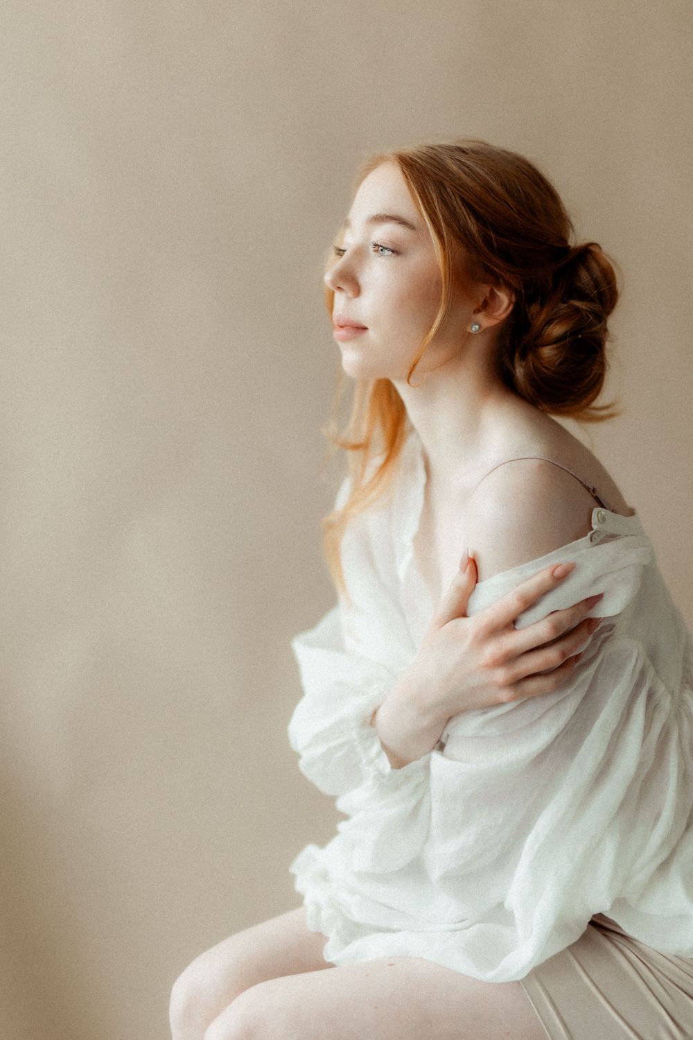 Romanttinen boudoir-kuvaus, jossa asiakas ilmentää itsensä rakastamisen ja kauneuden korostamista. Kuvassa näkyy pehmeitä valoja ja intiimiä