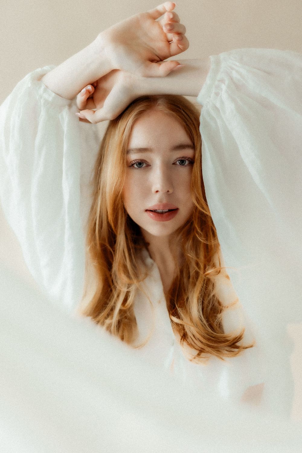 Romanttinen boudoir-kuvaus, jossa asiakas ilmentää itsensä rakastamisen ja kauneuden korostamista. Kuvassa näkyy pehmeitä valoja ja intiimiä