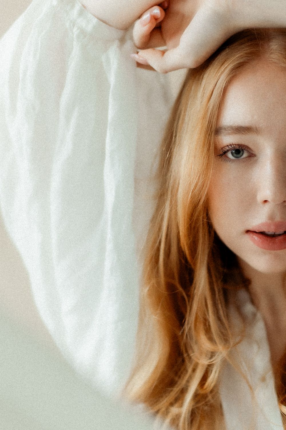 Romanttinen boudoir-kuvaus, jossa asiakas ilmentää itsensä rakastamisen ja kauneuden korostamista. Kuvassa näkyy pehmeitä valoja ja intiimiä