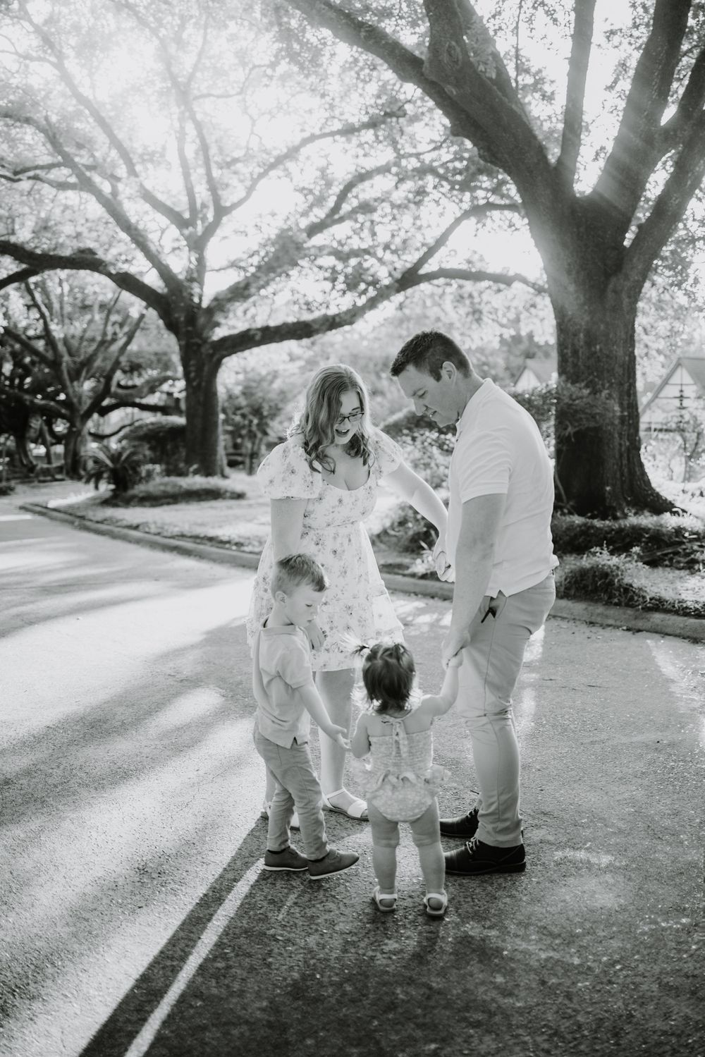 Black and white family portraits under majestic oak trees.
