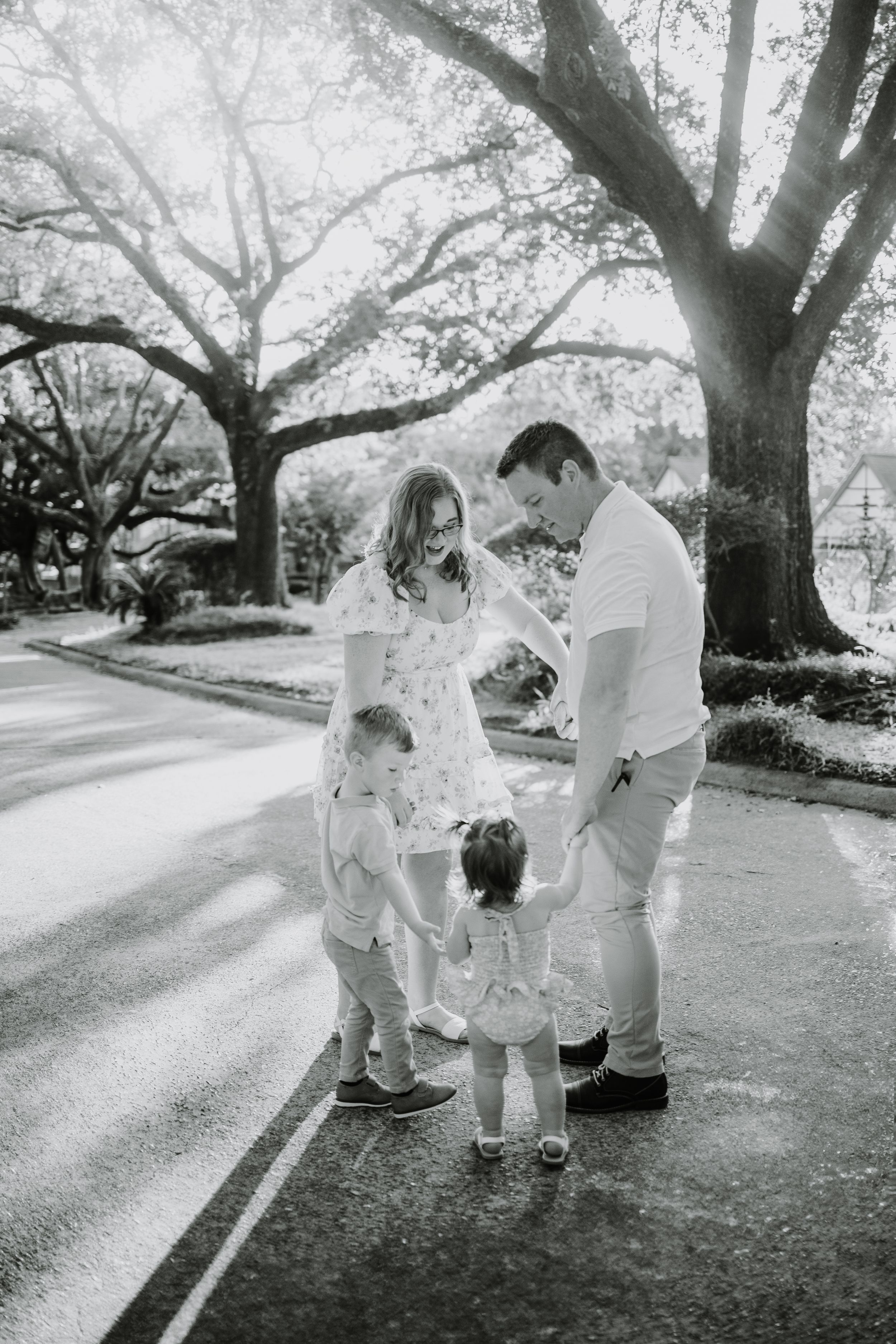 Black and white family portraits under majestic oak trees.