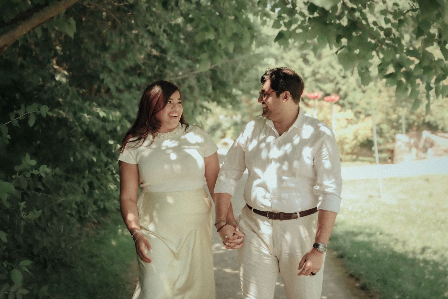 A tender wedding moment captured through a delicate veil in a garden setting.