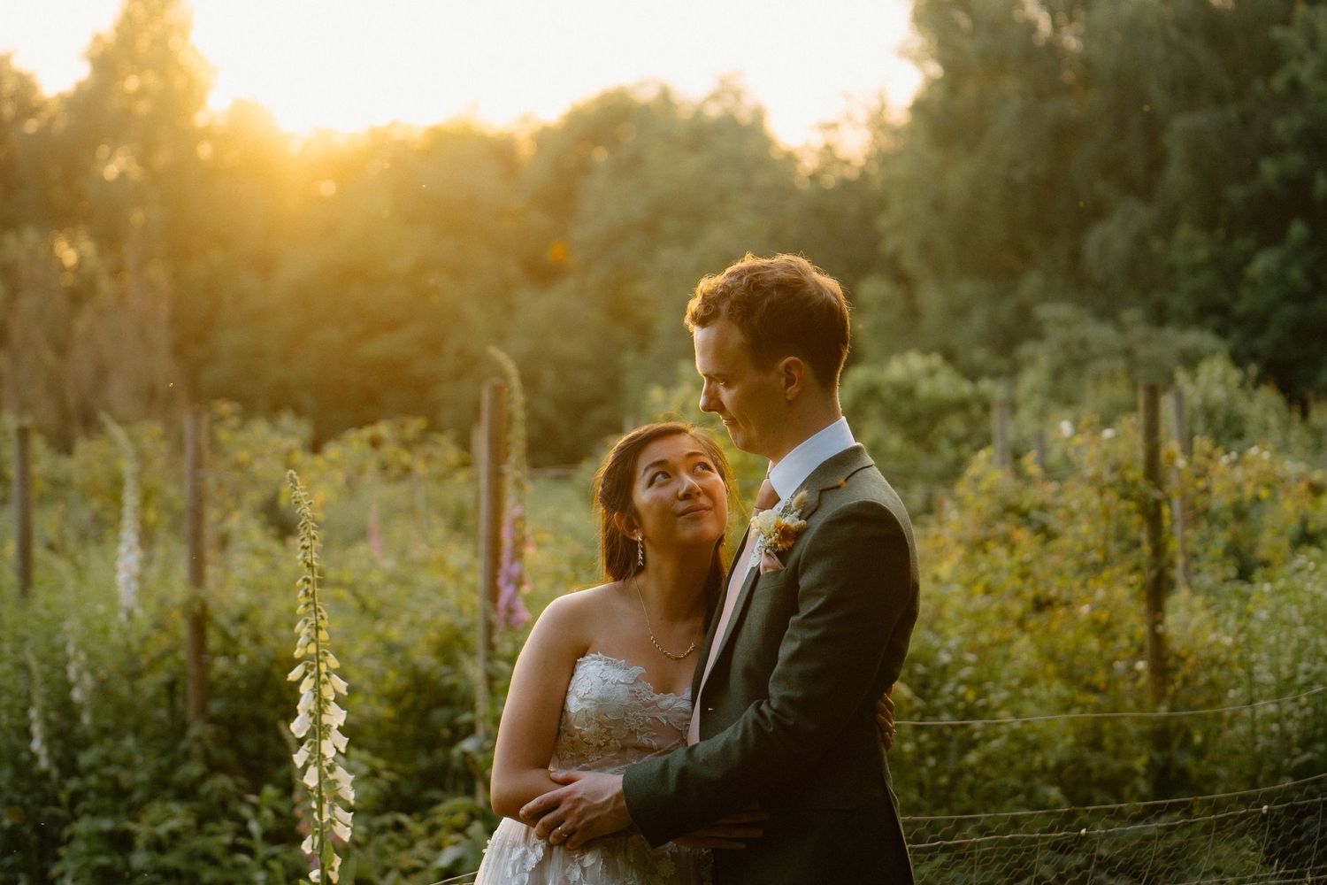 Golden hour portrait of a couple in a garden with glowing sunlight filtering through trees at Abbeywood Estate.