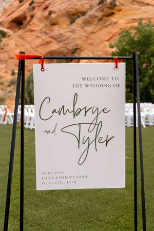 Wedding welcome signs displayed on metal stands at an outdoor venue.