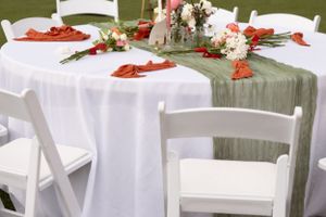 Wedding reception tables decorated with white linens and coral accents.