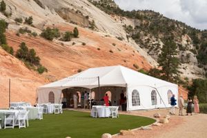 White wedding tent and reception setup with red rock cliffs in the background.