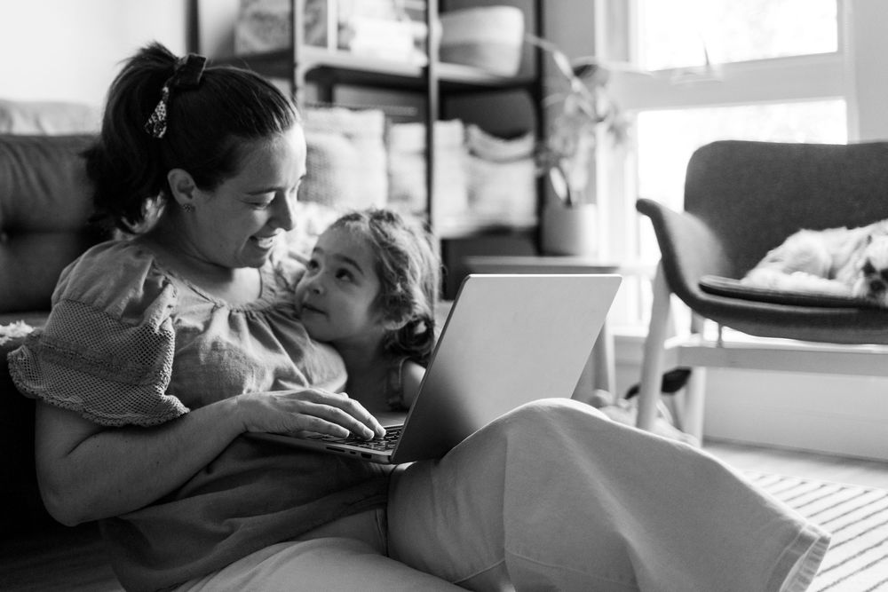 A tender black and white moment shared between parent and child while relaxing together on a couch at home.