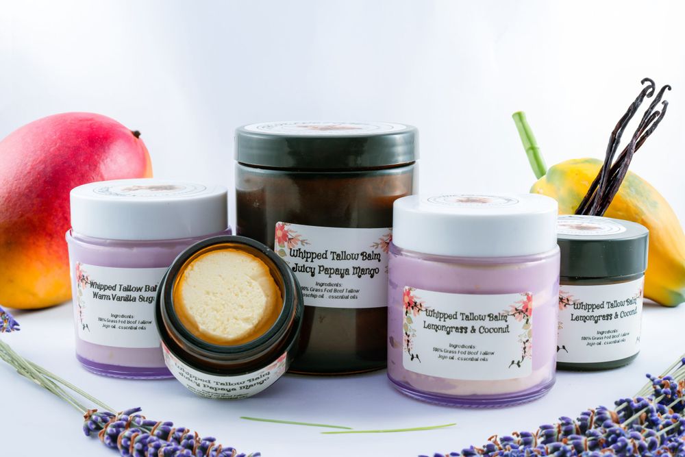 Natural skincare products arranged with fresh lavender sprigs and mango on white surface with soft lighting.
