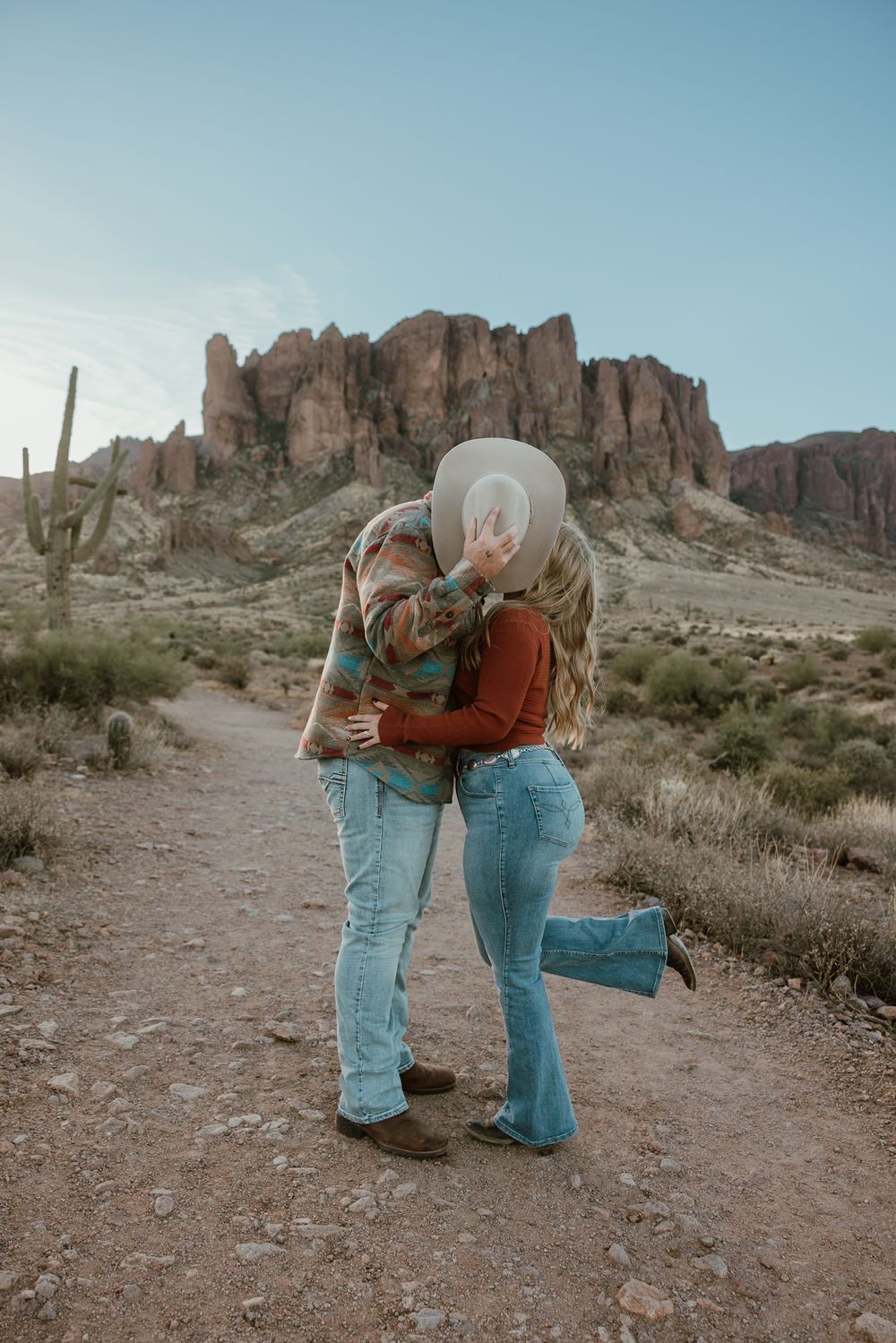 Hiding a secret kiss behind a cowboy hat in Apache Junction Arizona.