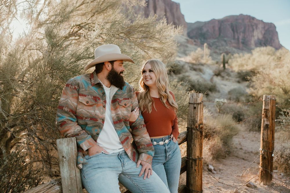 Resting along a rustic fence in the desert with the Superstition Mountains in the background.
