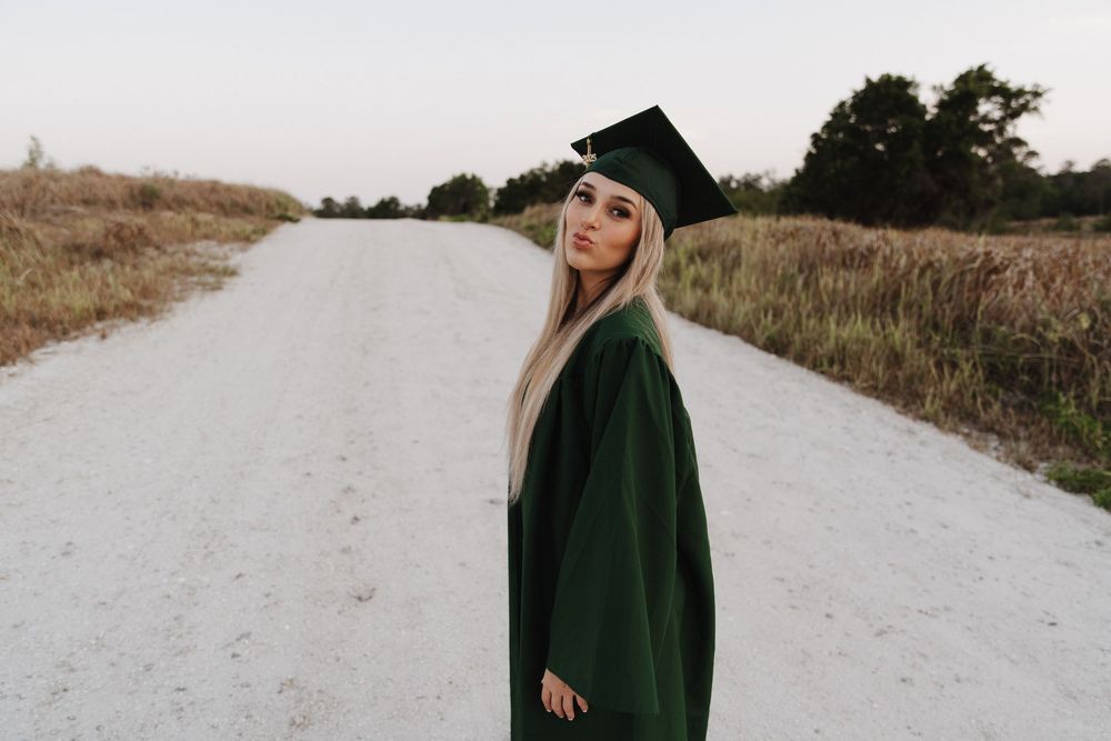 A series of outdoor photos showing someone in a dark green graduation gown walking along a white gravel path.
