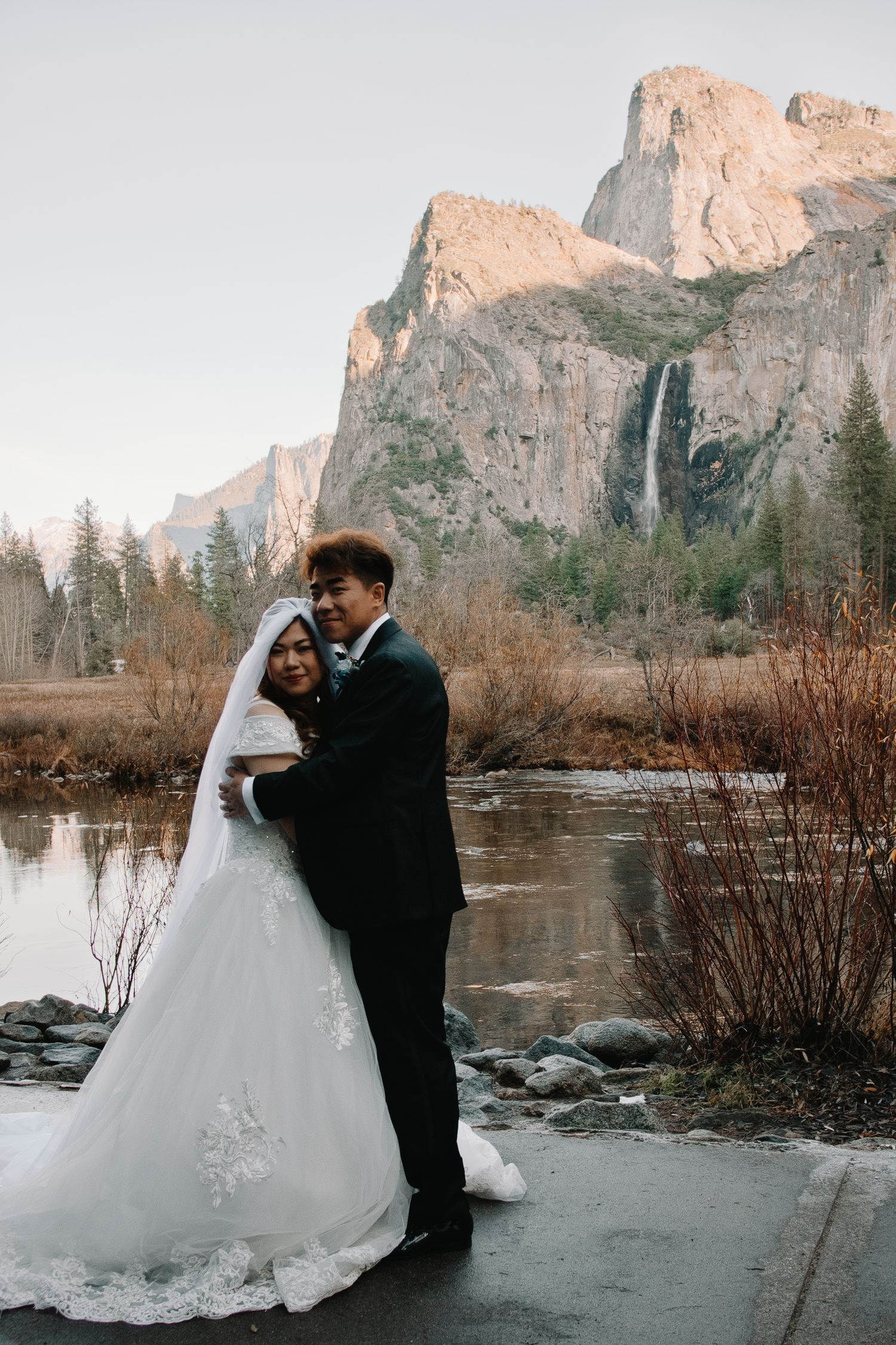Elopement bride and groom with lanterns to light them during blue hour with Yosemite National Park's Half Dome in the background